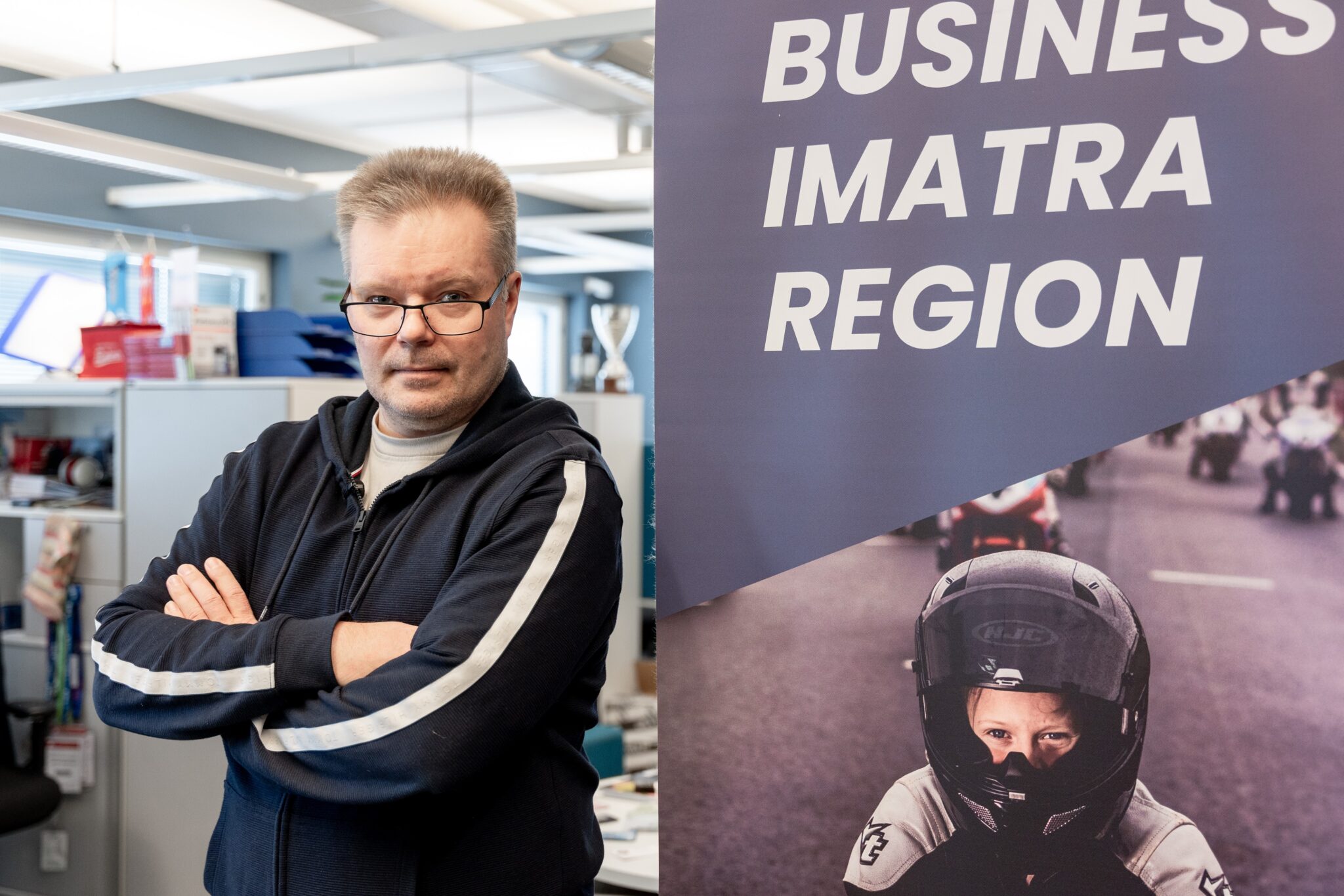 Antti Oravuo toimistolla Business Imatra Region julisteen vieressä.