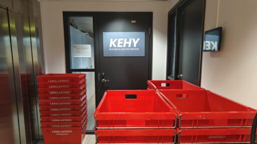 Punaisia muuttolaatikoita kasattuna käytävälle KEHYn oven eteen.