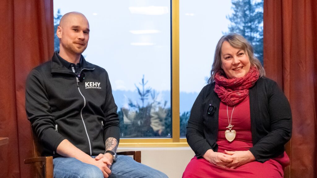 Kaksi henkilöä istuvat tuoleilla ikkunan edessä.